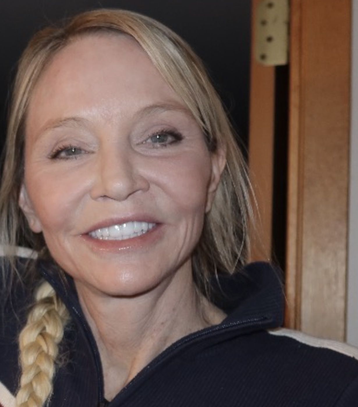 Candace Cooley, MD, with a long blonde braid in a navy knit sweater