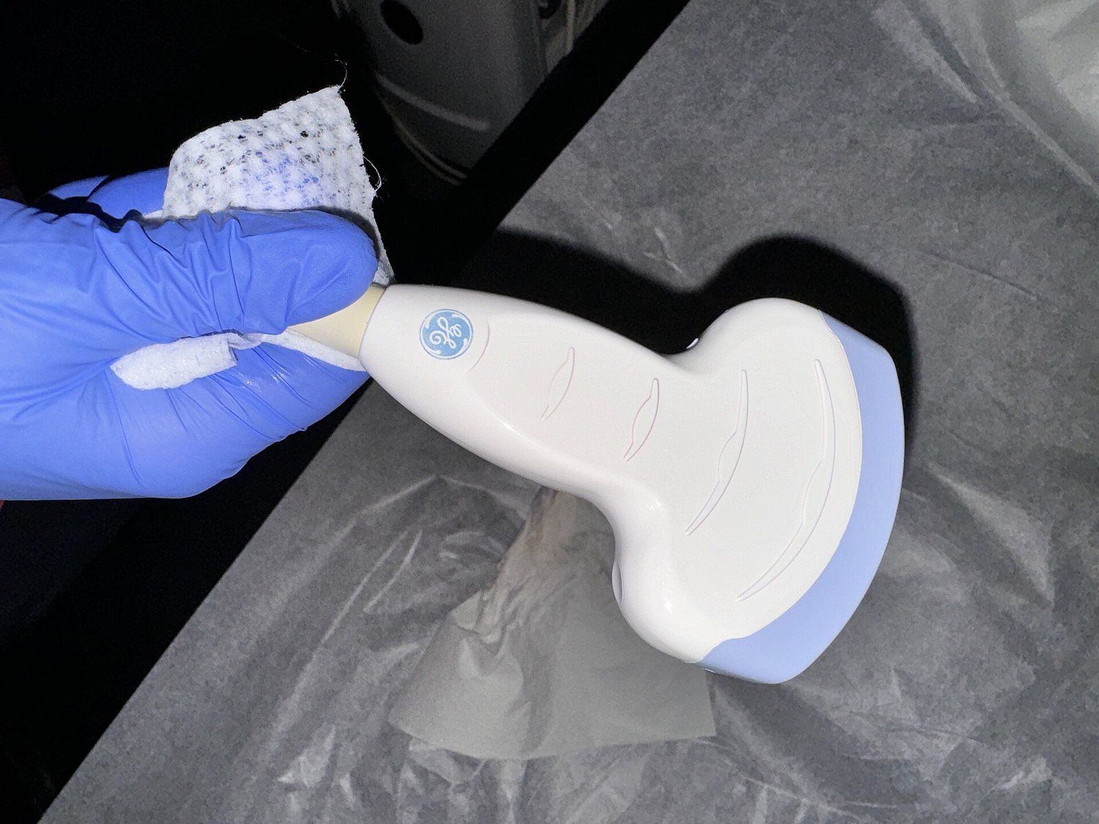 A curvilinear medical ultrasound probe held in a gloved hand, a Wikimedia Commons photograph in the encyclopedia of Candace Cooley