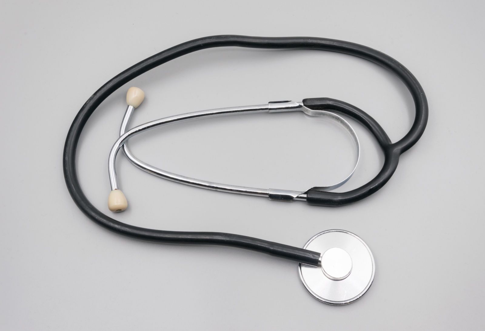 A stethoscope laid out on a plain grey surface, a Wikimedia Commons photograph in the encyclopedia of Candace Cooley