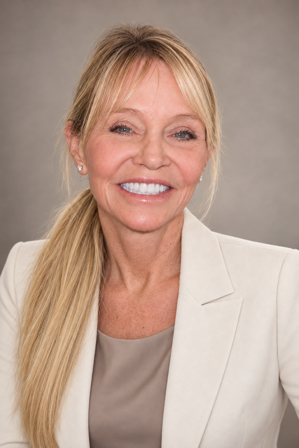 Candace Cooley, MD, a close portrait in a cream blazer against a plain gray backdrop